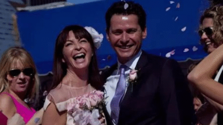 Bastien Boosten and Suzi Perry smiling at their wedding surrounded by guests and flower petals